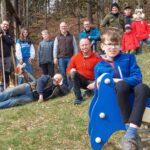 Teamfoto und Kind auf Federwippe